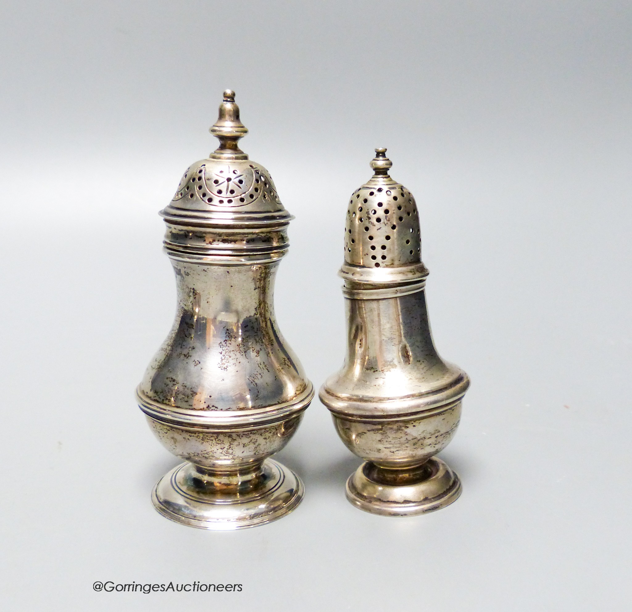 A Victorian silver baluster pepper pot, Charles Stuart Harris, London 1897, 11.2cm and an Edwardian silver baluster pepper, 1904, 112 grams.